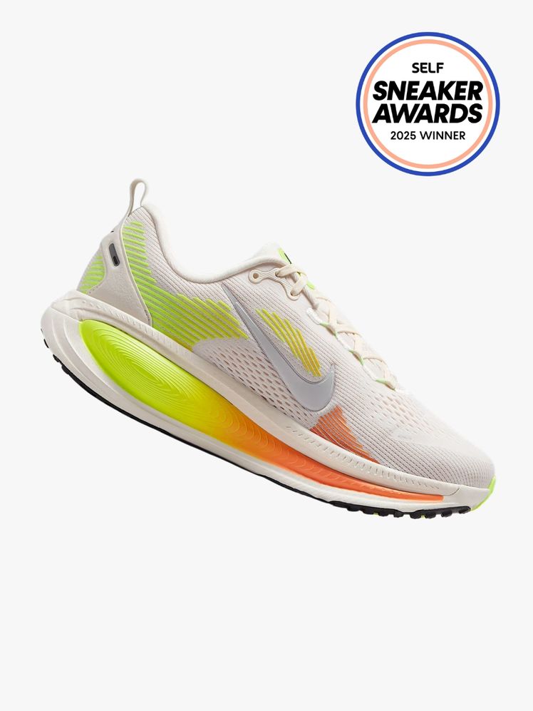 Nike Vomero 18 sneaker in white with greenyellow and orange accents. The SELF Sneaker Awards seal is in the top right...