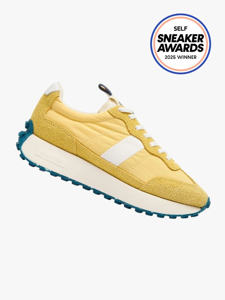 SeaVees Acorn Trainer in soft yellow with a cream and teal sole. The SELF Sneaker Awards seal is in the top right corner.